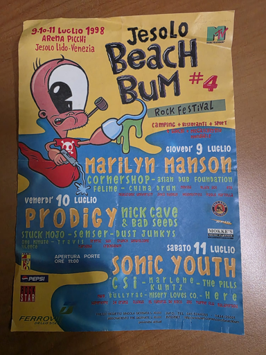 Immagine di un volantino colorato che pubblicizza un festival musicale chiamato "Jesolo Beach Bum #4". Il volantino presenta un personaggio cartoon rosso con un cappello nero e degli occhiali da sole. Il testo sul volantino indica che il festival si svolgerà dal 9 all'11 luglio 1998 ad Arena Piccola, Jesolo Lido-Venezia.  Sono elencati diversi artisti e gruppi musicali per ogni giorno del festival:

Giovedì 9 Luglio: Marilyn Manson, Cornershop, Asian Pub Foundation, Felino, China, Drum, Hayward, Black Ace, Btk, Systematic Universe, Servo, Sassler, Veinattrees, Facto Mariella.
Venerdì 10 Luglio: Prodigy, Nick Cave & Bad Seeds, Stuck Mojo, Sensator, Dust Junkys, One Minute, Travis, Typik, Sic, Crunch, Unwelcome, Tackdown.
Sabato 11 Luglio: Sonic Youth, Csi, Kuntz, The Pills, Bullyrag, Misery Loves, Co-Heré, Waterfront, 28 Crash, Fluxus, El Funeral De Kiko, Ade Turbe.

In basso sul volantino sono presenti loghi di sponsor come Pepsi, Star, Ferro e Mokke. C'è anche un numero di telefono (041/5464055) e un indirizzo web (http://www.jesolobeachbum.com).

