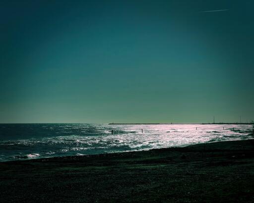 Spiaggia al tramonto con riflessi luminosi sull'acqua
