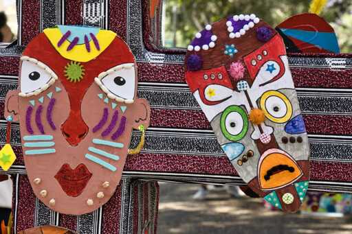 opera d'arte che rappresenta due volti stilizzati nello stile dell'arte africana (maschere), con grandi occhi e linee di decorazione sul volto.