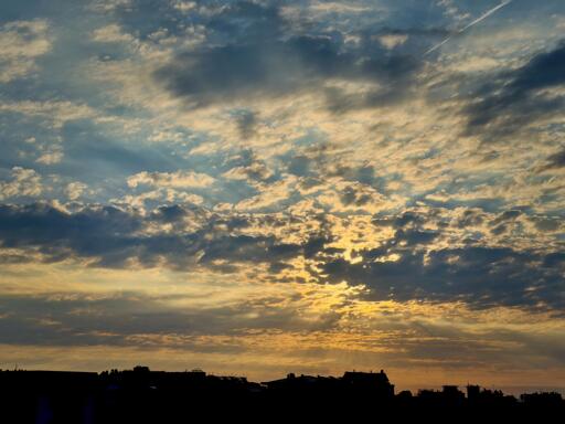 Sole all’alba dietro le nuvole sopra la città.
