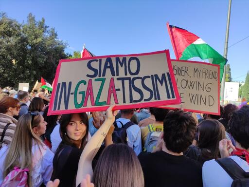 Foto di un corteo per la Palestina, in Italia. Il cartello in primo piano dice "SIAMO IN-GAZA-TISSIMI"